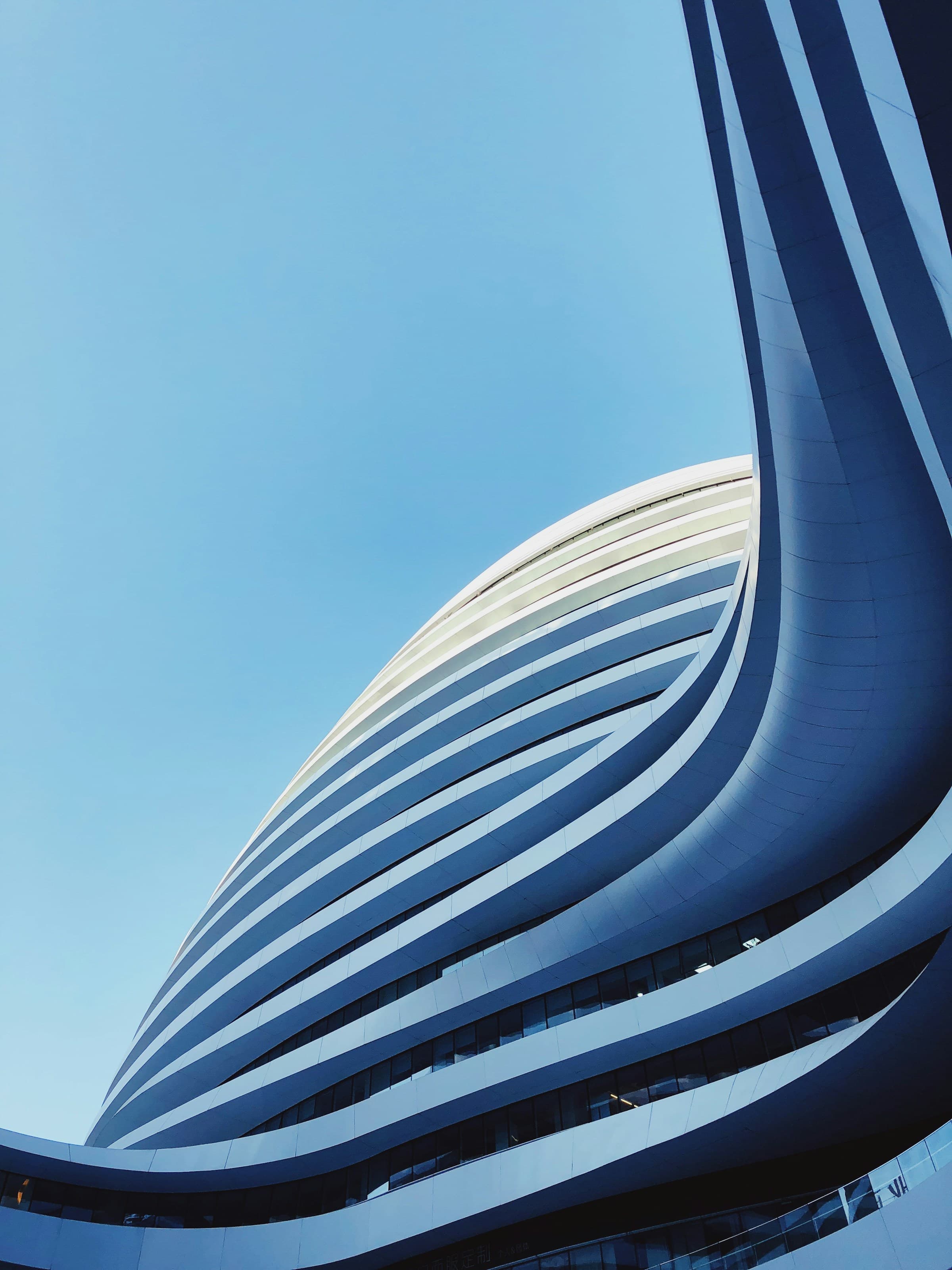 Geschwungene moderne Architektur vor klarem blauem Himmel